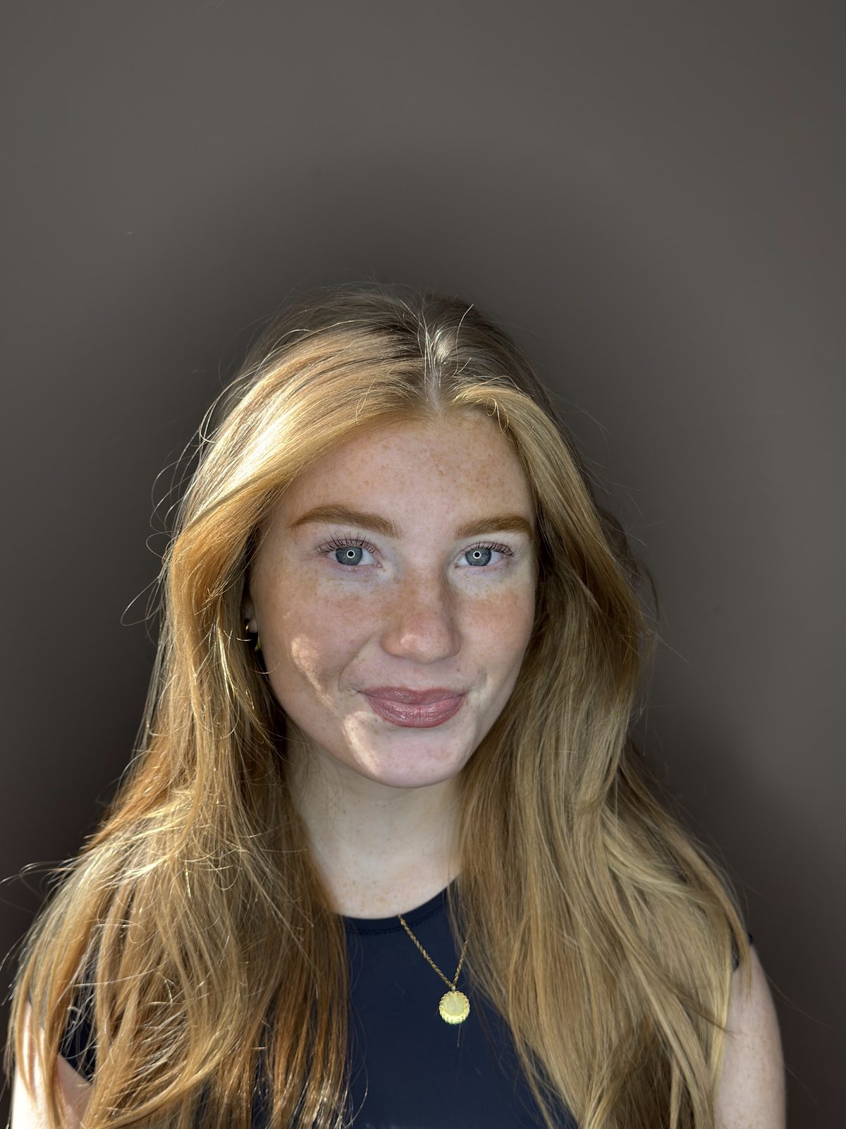 Portret tegen de taupe studiowand van Pipasbeautyroom